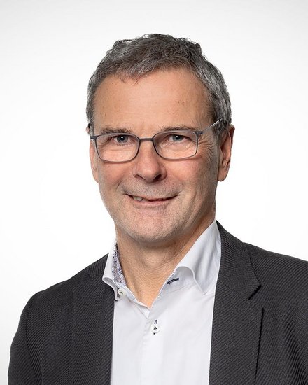 Porträt eines Mannes mit Brille vor neutralem Hintergrund