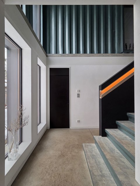 Moderner Innenraum mit Treppe, großen Fenstern und minimalistischem Design