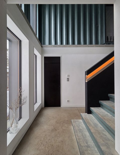 Moderner Innenraum mit Treppe, großen Fenstern und minimalistischem Design