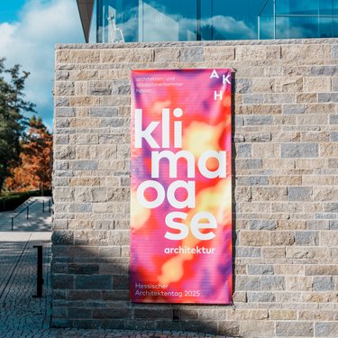 Banner mit der Aufschrift „klima oase architektur“ am Gebäude, Hessischer Architektentag 2025.