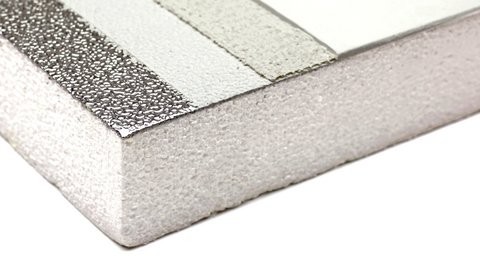 Detail einer silbrig‑weißen Dämmplatte; folierte, körnige Oberfläche und dicker Hartschaumkern an der Kante.