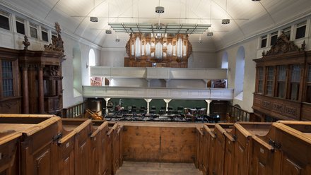 Innenraum eines historischen Konzerthauses mit Orgel, Empore und Holzbestuhlung.