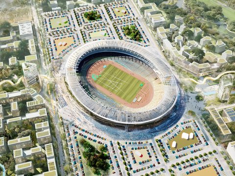 Vogelperspektive auf ein großes, offenes, ovales Stadion mit einer grünen Rasenfläche und einer roten Laufbahn im Zentrum. Das Stadion ist von einem großen Parkplatzgelände im Norden und Westen umgeben, auf dem viele bunte Autos parken. Östlich und südlich erstreckt sich eine parkähnliche Anlage mit Bäumen und modernen, terrassierten Wohngebäuden, die teilweise begrünte Dächer aufweisen.