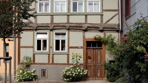 Saniertes Fachwerkhaus mit begrüntem Innenhof und historischer Holzfassade.