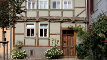 Saniertes Fachwerkhaus mit begrüntem Innenhof und historischer Holzfassade.