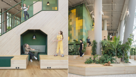 Multifunktionaler Innenraum: Holzpodeste, Pflanzen, Treppen und Menschen in Bewegung, kombiniert mit Spiel- und Arbeitszonen.