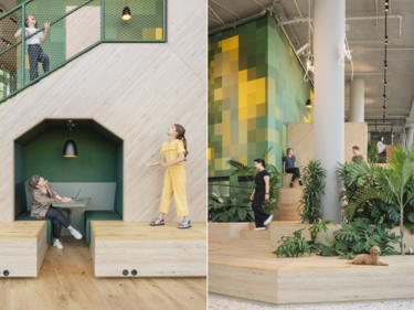 Multifunktionaler Innenraum: Holzpodeste, Pflanzen, Treppen und Menschen in Bewegung, kombiniert mit Spiel- und Arbeitszonen.