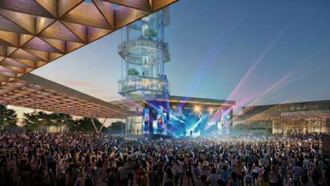 Großes Open Air Konzert mit dichter Menschenmenge vor einer Bühne mit farbiger Lichtshow. Dahinter erhebt sich ein hoher transparenter Turm auf dem Expo Gelände.