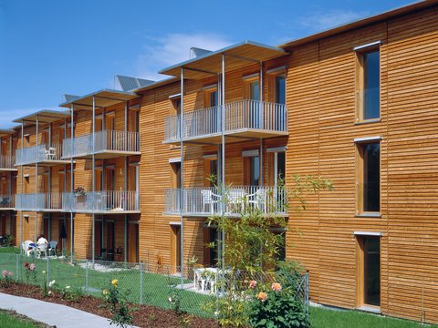 Hausfassade mit Holz und Balkonen