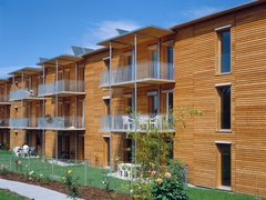 Hausfassade mit Holz und Balkonen