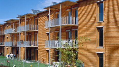 Hausfassade mit Holz und Balkonen