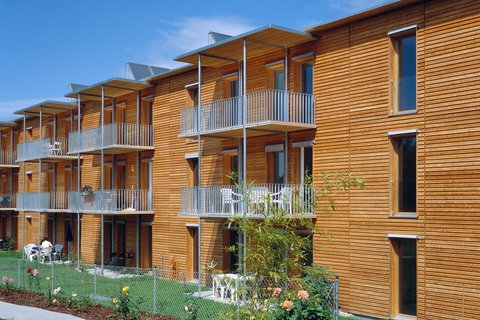 Hausfassade mit Holz und Balkonen