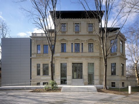 Historisches Gebäude mit neuer Erweiterung und sanierter Fassade.