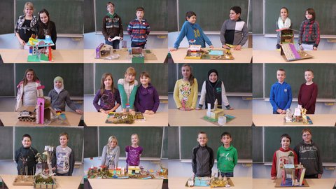 "Ein Mosaik aus zwölf Porträtfotos. Jedes Bild zeigt ein oder zwei Schüler, die stolz vor einer Schultafel stehen und ihre selbstgebastelten Architektur-Modelle aus Pappe, Papier und Naturmaterialien präsentieren. Die Modelle sind sehr unterschiedlich gestaltet, von farbenfrohen Häusern bis hin zu Burgruinen."