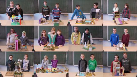 "Ein Mosaik aus zwölf Porträtfotos. Jedes Bild zeigt ein oder zwei Schüler, die stolz vor einer Schultafel stehen und ihre selbstgebastelten Architektur-Modelle aus Pappe, Papier und Naturmaterialien präsentieren. Die Modelle sind sehr unterschiedlich gestaltet, von farbenfrohen Häusern bis hin zu Burgruinen."