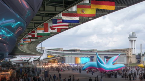 Weitläufiger Expo Platz mit dichtem Publikum, hängenden Länderflaggen und einem historischen Flugzeug unter einer großen Dachkonstruktion. Im Hintergrund steht ein Turm mit Expo Berlin Schriftzug.