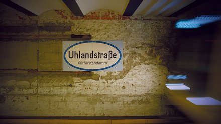 U-Bahnhofsschild „Uhlandstraße“ an einer historischen Wand.