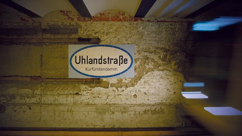 U-Bahnhofsschild „Uhlandstraße“ an einer historischen Wand.