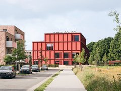 Bild einer Straße, an deren Ende sich eine moderne Grundschule befindet