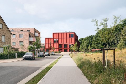 Bild einer Straße, an deren Ende sich eine moderne Grundschule befindet