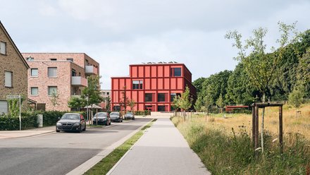 Bild einer Straße, an deren Ende sich eine moderne Grundschule befindet