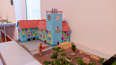 unt gestaltetes Architekturmodell eines Schulgebäudes mit Uhrturm und neugestaltetem Schulhof als Ergebnis eines Schulprojekts.