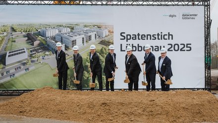 Spatenanstich des Datacenter in Lübbenau; 5 Personen stehen mit Spaten vor einem Bauplakat
