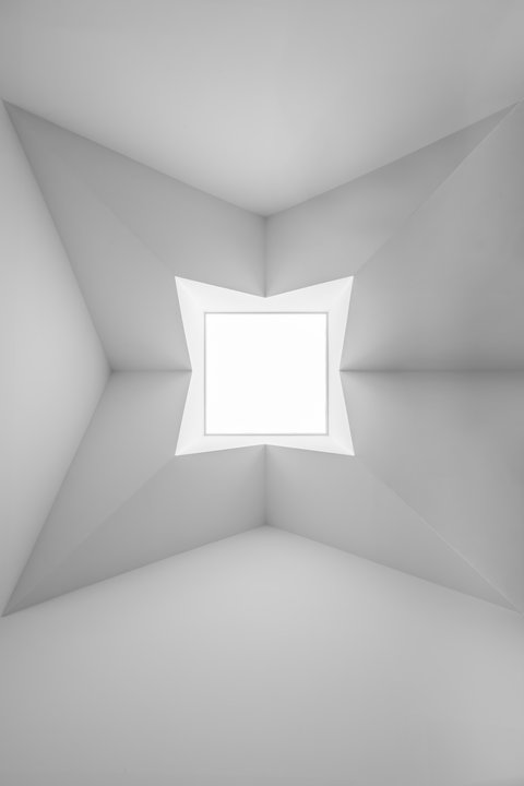 Quadratisches Oberlicht mit skulptural gefalteter Decke, das den minimalistischen Innenraum mit Tageslicht erhellt.