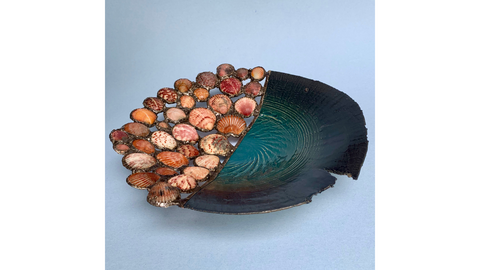 Flache Schale mit türkisgrüner Glasur; eine Hälfte mit dicht gesetzten Muschelschalen eingefasst, dunkler Rand beschädigt.