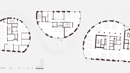 Grundriss des ersten Obergeschosses in schematischer Grafik: drei geschwungene, halbrunde Gebäudeteile sind nebeneinander angeordnet und durch Wege verbunden. Eingetragen sind Räume mit Möbel‑ und Arbeitsplatzzeichen, Treppenhäuser, Aufzugsräume, Sanitärzellen und Erschließungsflure; Fensteröffnungen sind als dünne Wandlücken dargestellt. Unten links Maßstabsleiste und Legende.
