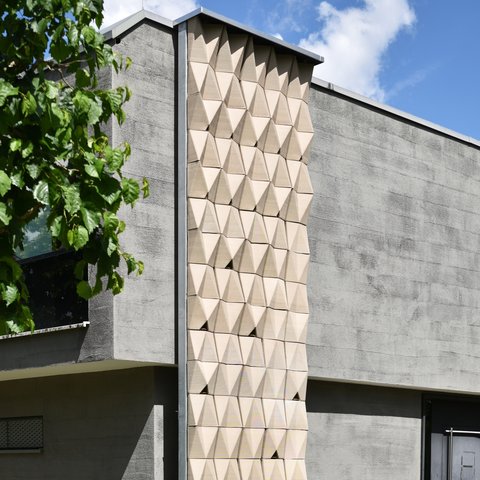 Nistfassade Neuperlach: Gebäudefassade mit dreidimensionalen, wabenartigen Nistmodulen.
