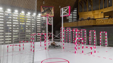 Zeitgenössische Kunstinstallation in einer Kirche mit Basketballkörben, kleinen Toren und neonpink markierten Spielfeldern.