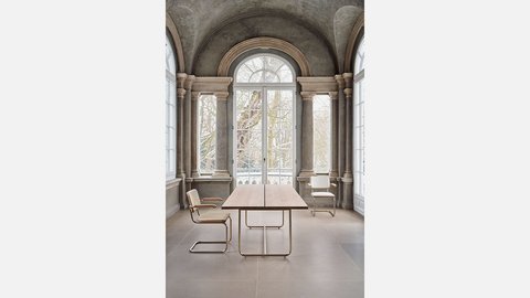 Moderner Schreibtisch und Stuhl vor einer Fensterwand