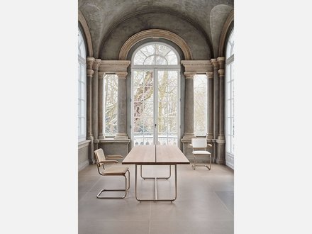 Moderner Schreibtisch und Stuhl vor einer Fensterwand