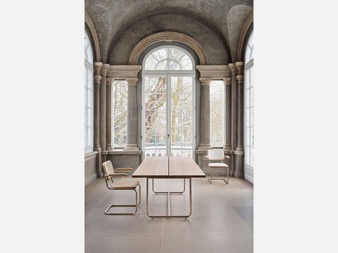 Moderner Schreibtisch und Stuhl vor einer Fensterwand