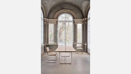 Moderner Schreibtisch und Stuhl vor einer Fensterwand