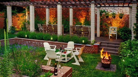Gemütlicher, beleuchteter Garten mit Sitzgruppe, Feuerkorb und Pergola vor Backsteinwand.