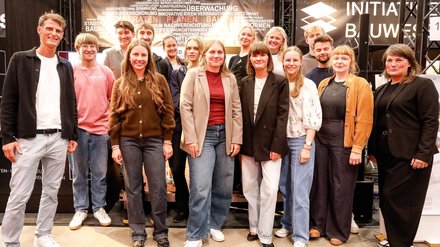Große Gruppe von Teilnehmenden und Preisträger:innen auf einer Bühne bei einer Veranstaltung.
