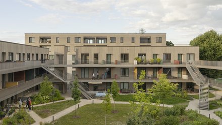 Blick auf eine moderne Wohnanlage mit umgebendem Garten und treppenartig angeordneten Terrassen.