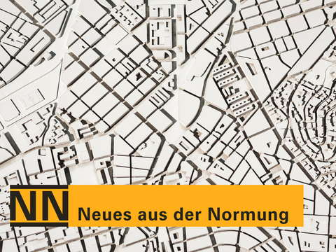 „Ein grafischer Stadtplan als Hintergrund mit einem orangefarbenen Banner am unteren Rand und dem Schriftzug ‚NN Neues aus der Normung‘.“