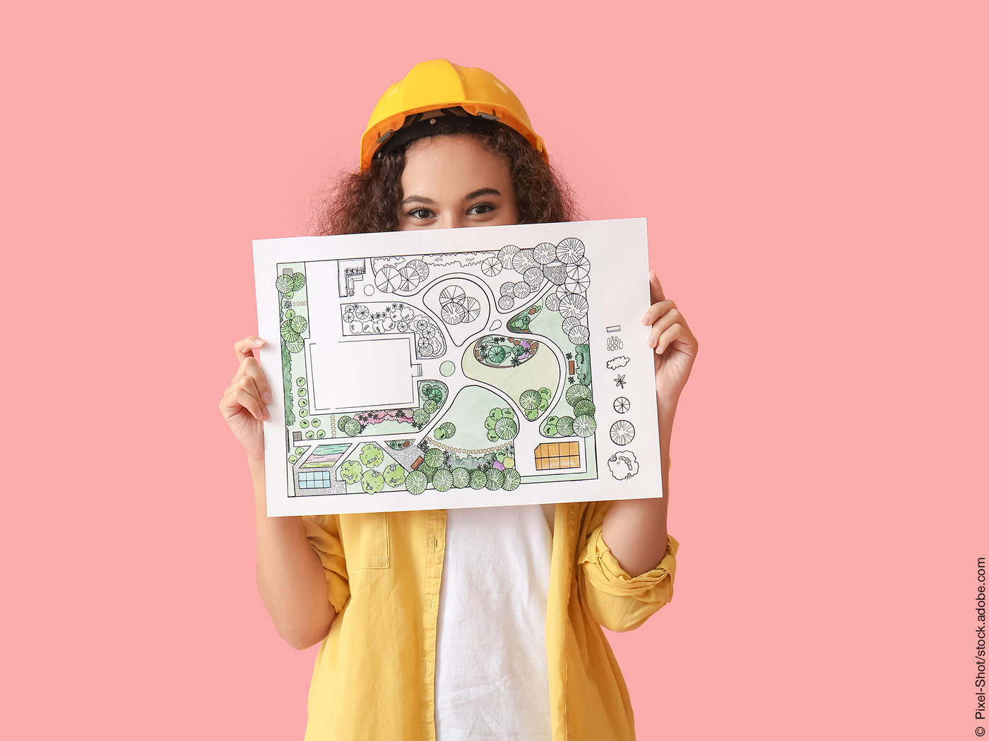 Person mit Bauhelm und Zeichnung eines Gartens