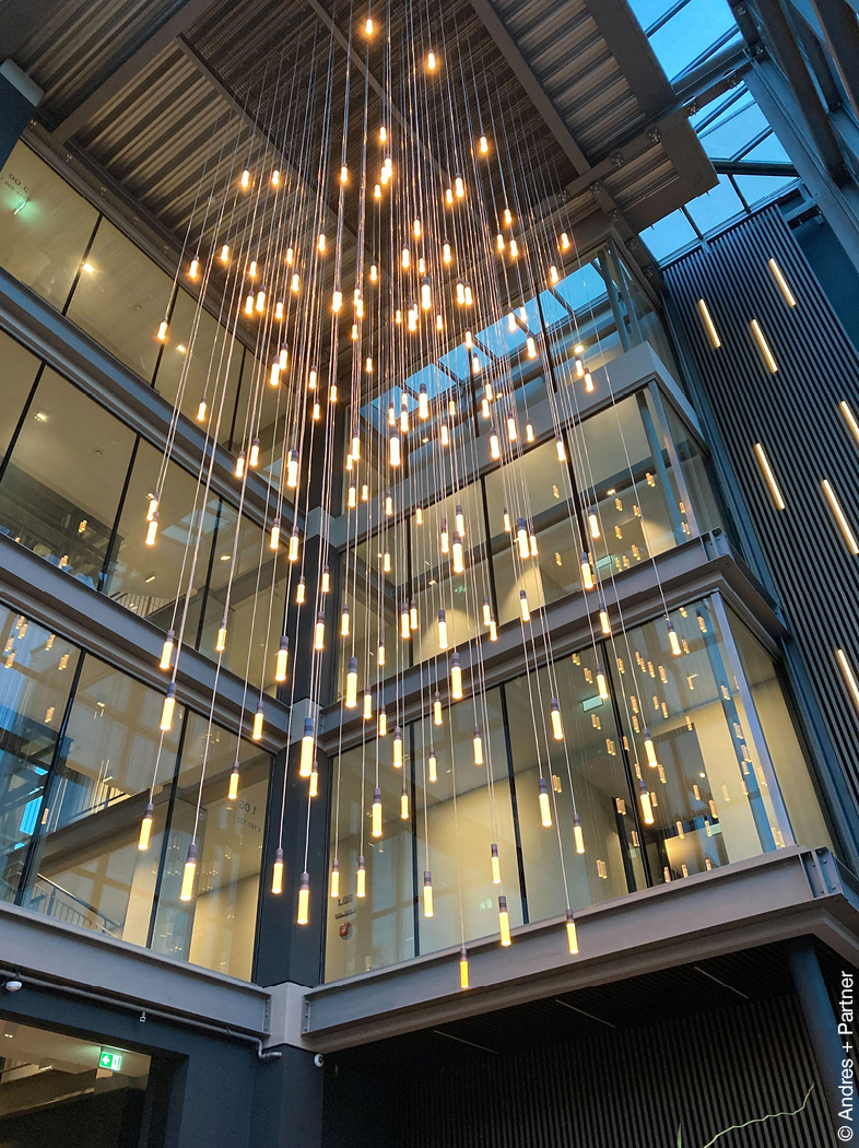 Pendelleuchten in einem verglasten Foyer.