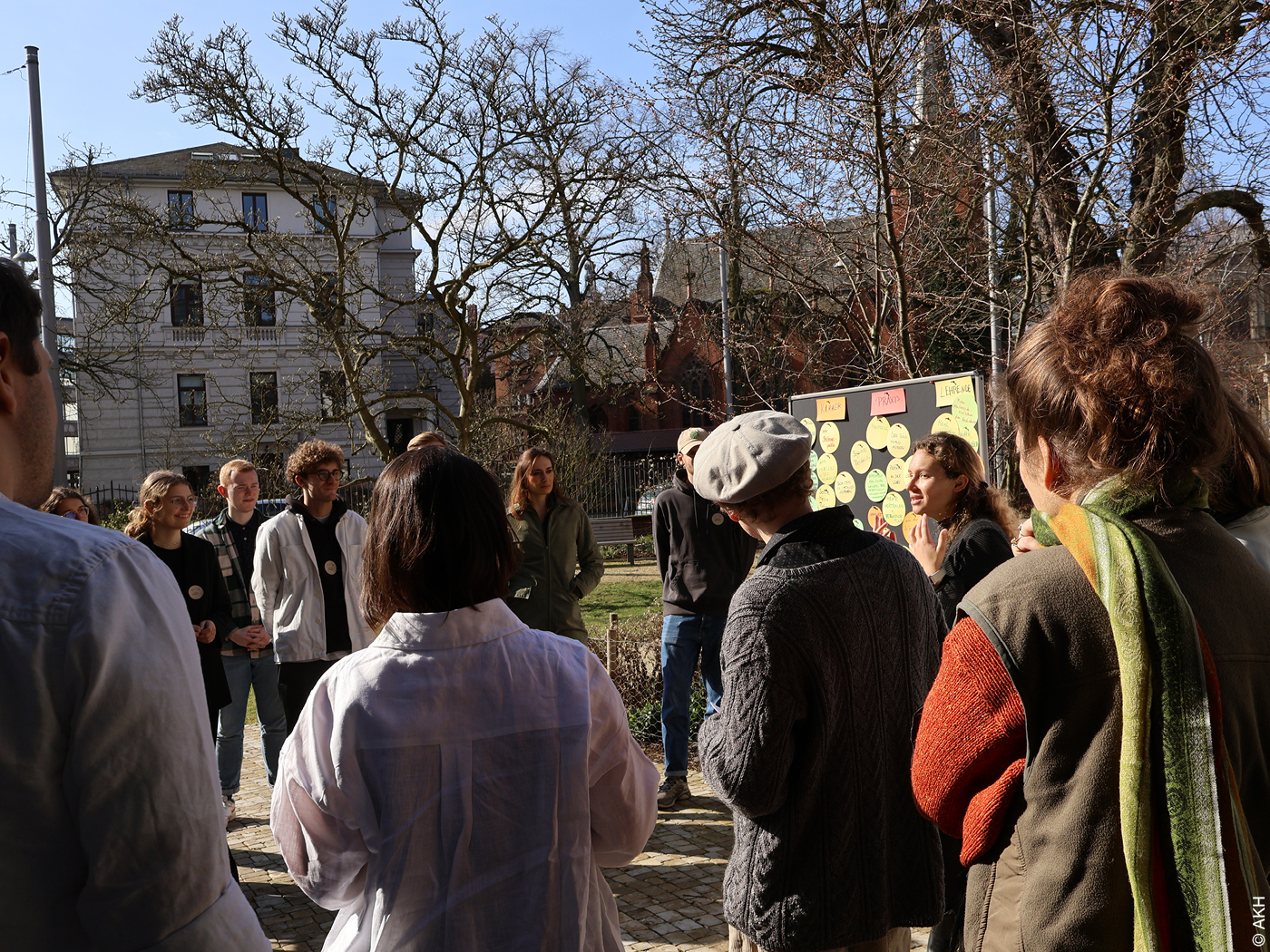 Menschen vor einen Pinwand in einer Grünanlage