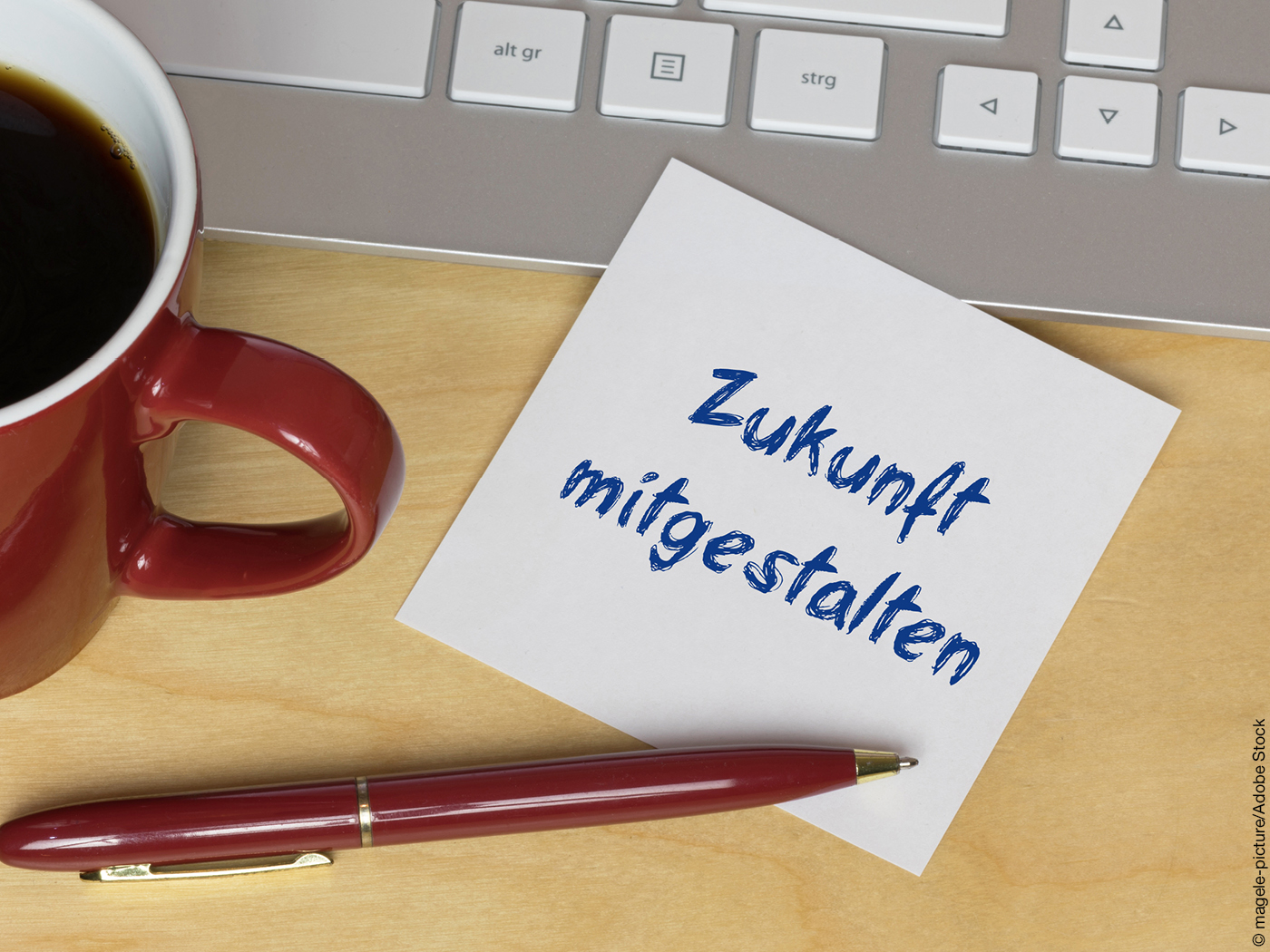 Zettel mit der Aufschrift "Zukunft gestalten" neben Tatstaur, Kuli und Kaffeetasse