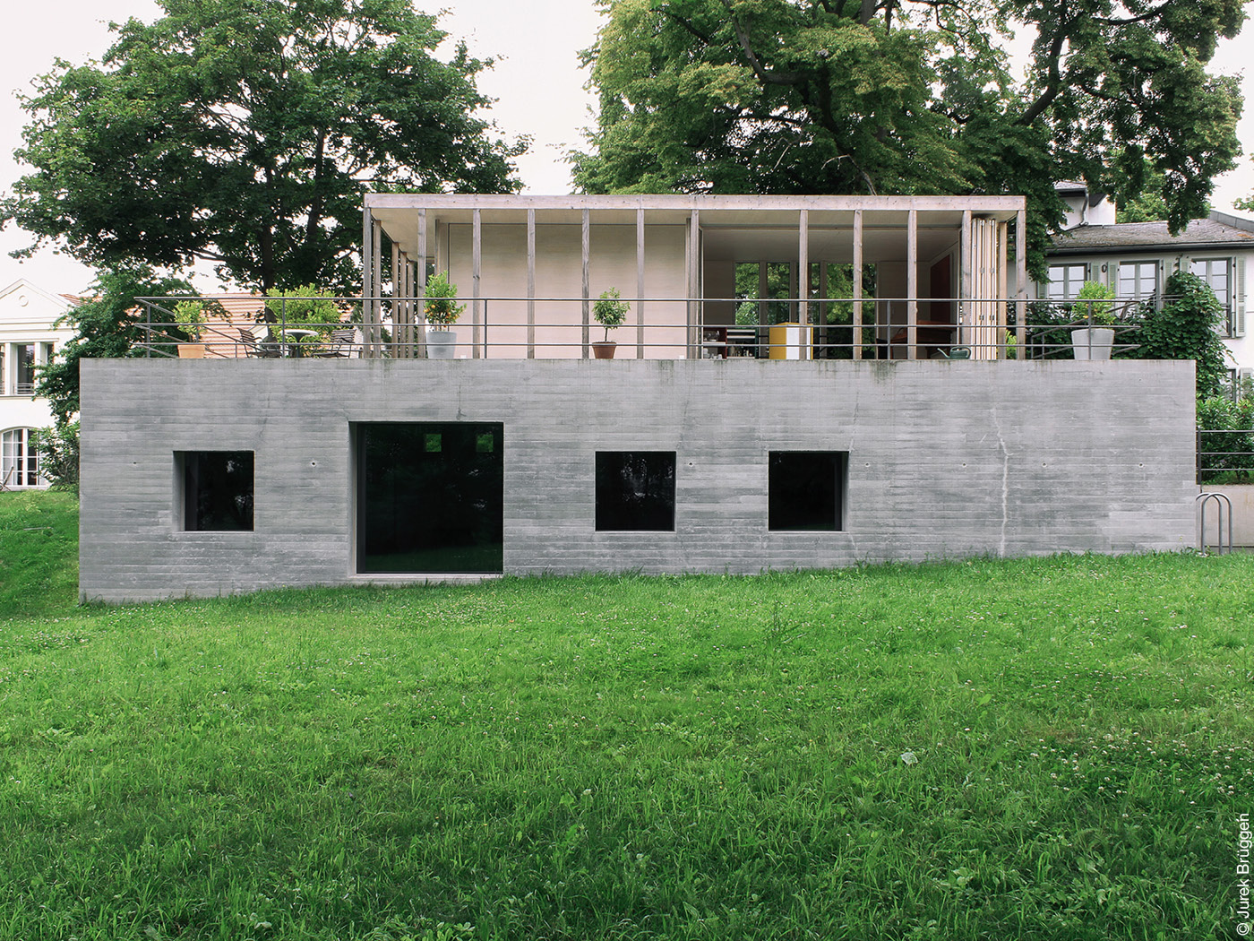 Einfamilienhaus mit Betonsockel, Dachterrasse und leichtem Aufbau
