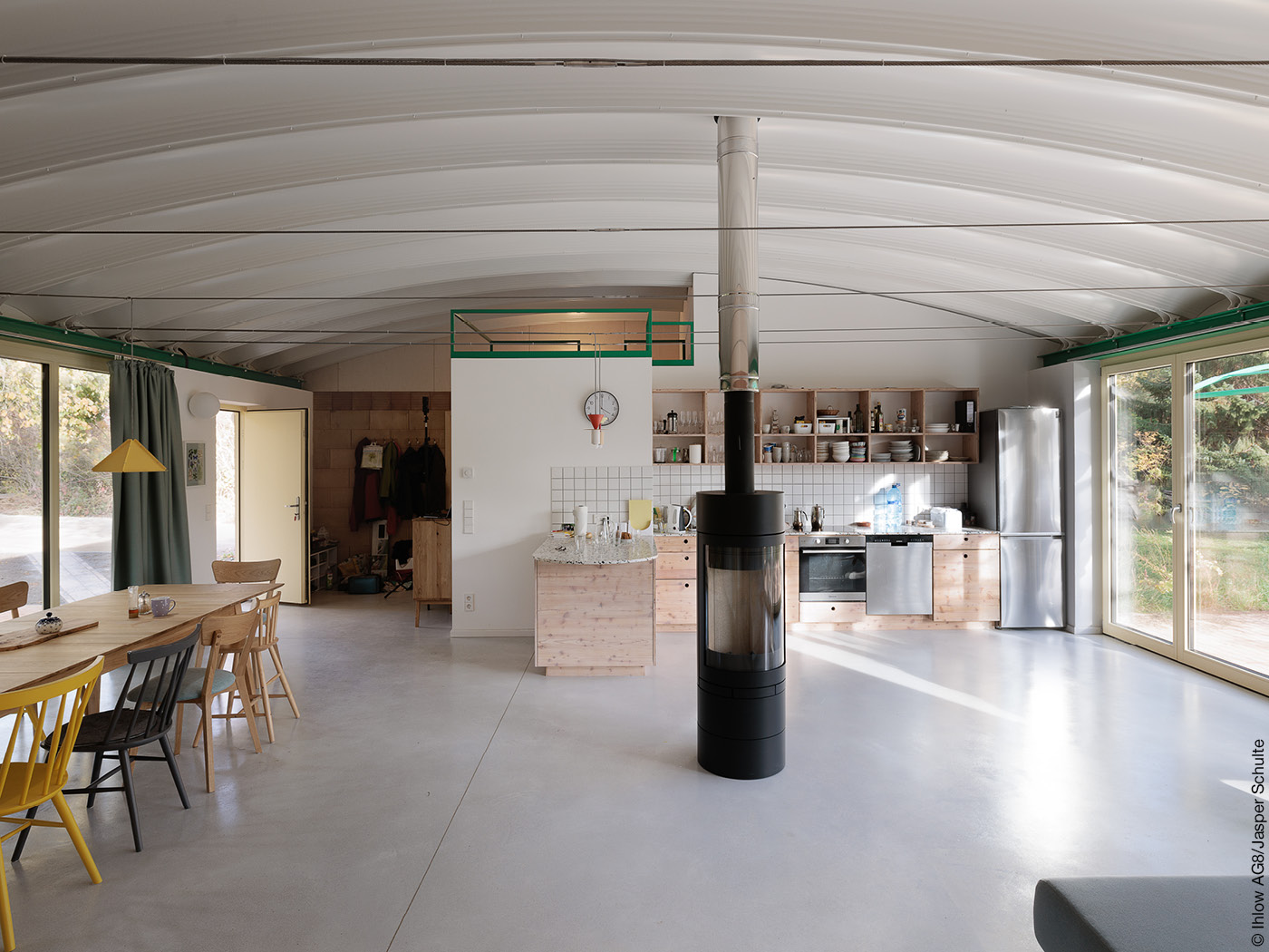 Wohnhalle mit offener Küche, Holzofen und gewölbter Decke