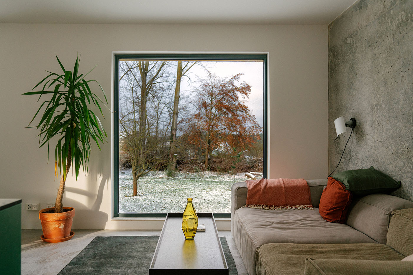Wohnzimmer mit einem bodentiefen Fenster mit Blick in einen Garten