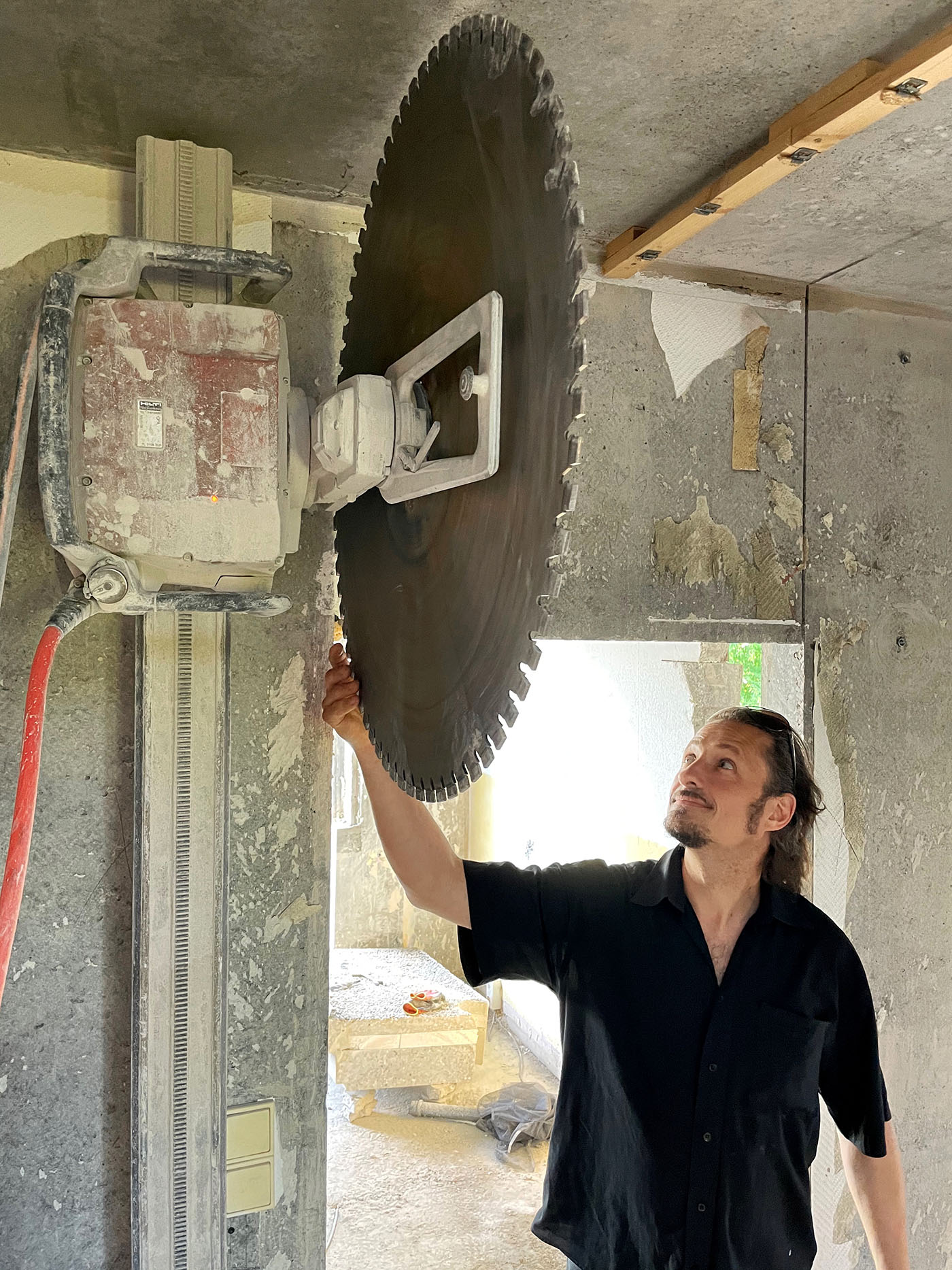 Durchbruch in einem Haus mit einer großen Betonsäge, die an der Decke hängt.