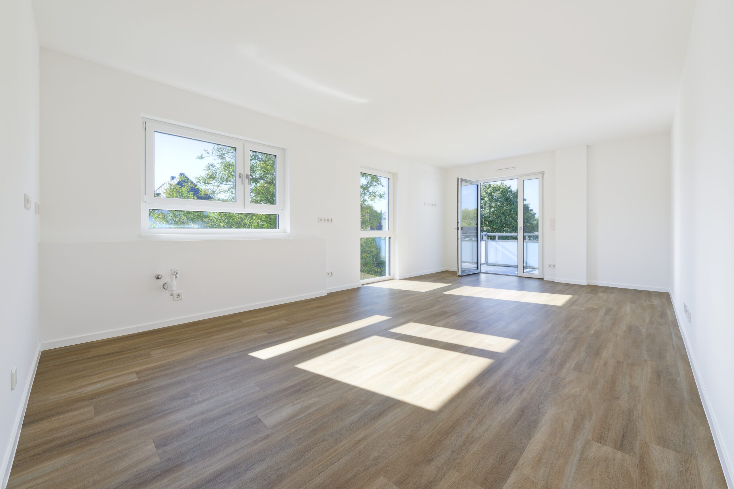 Wohnung mit weißen Wänden und Holzfußboden