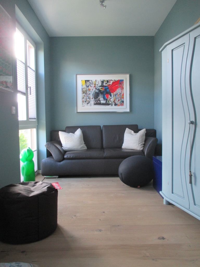 Wohnzimmer mit Sofa und petrolfarbener Wand